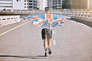 Winner, flag and fitness man running on the city road celebrates winning achievement in summer. Sports, training and