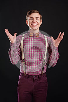 Always winner! Handsome young scientist in vintage shirt and bow tie gesturing keeping hands up and laughing while standing