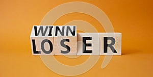 Winner and Loser symbol. Turned wooden cubes with words Winner and Loser. Beautiful orange background. Business and Winner and