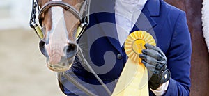 A Winner With Yellow Ribbon and Smiling Horse