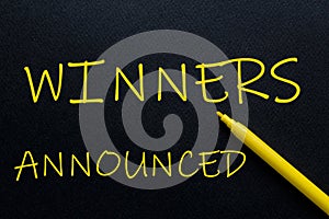 Winners Announced Yellow Pen with yellow text own rent at the black background photo
