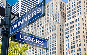 Winners losers crossroads street sign. Highrise buildings background photo