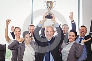 Winning business team with an executive holding trophy