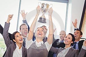 Winning business team with an executive holding trophy