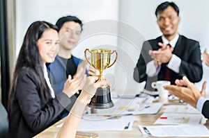 Winning business team gold trophy , business team happy consent and successful business team rewarded photo