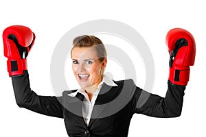 Winning business woman wearing boxing gloves