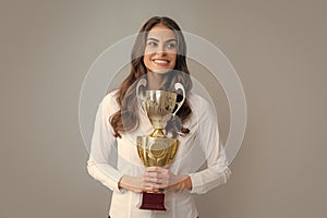 Winning businesswoman holding a trophy. Business woman with prize. Business woman with golden cup and fist up gesturing
