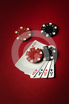 A winning playing card combination of four aces in poker or four of a kind or quads and chips. Concept of luck or fortune in