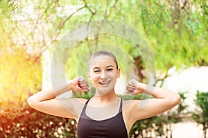 Winning, success concept. Beautiful, fitness sport girl rejoices in victory, raises her hands up.