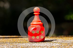 Winning, success simple abstract concept, single red toy game piece, chess pawn standing on the red board game dice showing six