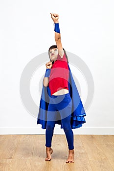 Winning super hero child playing with a powerful arm raised