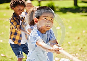 The winning team works as one. a group of kids playing a game of tug of war at summer camp.