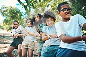 The winning team works as one. a group of teenagers playing a game of tug of war at summer camp.