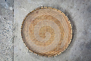 Bamboo winnowing basket on cement floor background