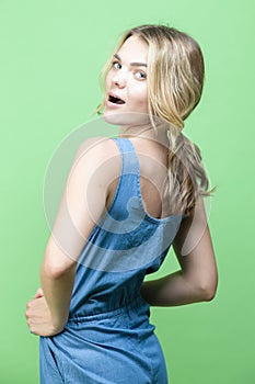 Winsome Caucasian Blond Girl In blue suite Posing In Summer outfit While looking Backwards With Positive Expression Over Summer