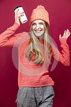 Winsome Positive Young Happy Emotional Cheerful Caucasian Girl Laughing In Knitted Autumn Hat and Sweater With Cup of Coffee on