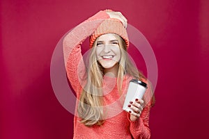 Winsome Positive Young Happy Emotional Cheerful Caucasian Girl Laughing In Knitted Autumn Hat and Sweater With Cup of Coffee on