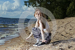 Winsome Young Happy Smiling Caucasian Brunette Girl Posing in Beach Clothing While Resting and Having Fun At Seashore During Sunny