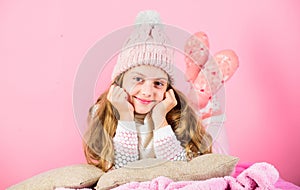 Winter accessory concept. Girl long hair dream pink background. Kid dreamy face wear knitted accessory. Kid girl wear