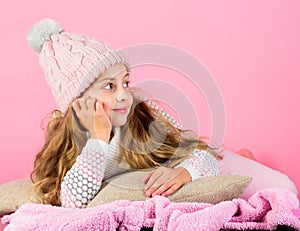 Winter accessory concept. Girl long hair dream pink background. Kid dreamy wear knitted hat. Winter rest and relax