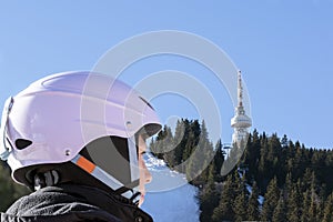 Winter active family vacation in ski resort concept. Boy skier in helmet, ski slope in background. Pamporovo, Bulgaria