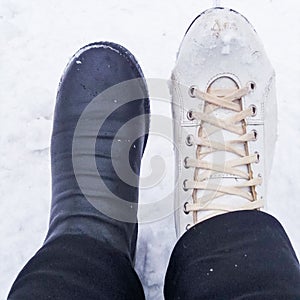 Winter activities - the photo shows two female feet - one in a black boot, the second leg is shod with old white figure skates