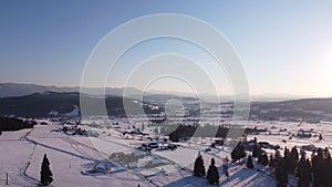 Winter Aerial Landscape with traditional houses and pine tree forest. Christmas time