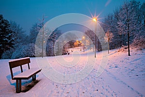 Winter alley with benches and lanterns at night