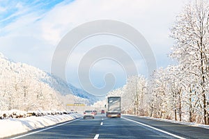 Winter alpine highway road landscape with beautiful white covered snow trees, mountains and blue sky on background at