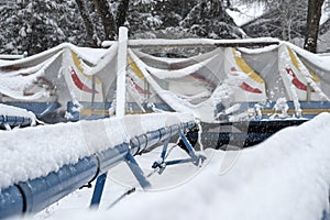 Roller coaster cowered with snow in amusement park in winter