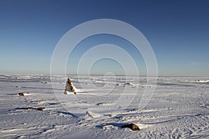 Winter arctic landscape with a small Inukshuk