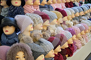 Winter and autumnal warm hats on mannequins in a shop window