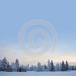 Winter background with cabin and copyspace on sky