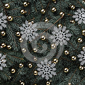 Winter background of fir branches. Adorned with gold baubles. Snowflakes silver. Christmas card. Top view. Xmas congratulations
