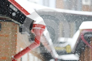 Winter background - snowy winter houses and drainpipes in defocus.