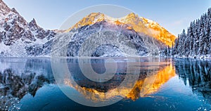 Winter background. Winter landscape with mountains reflected in clear frozen lake.