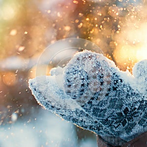 Winter Background - Woman hands in gloves with Flying Snowflakes