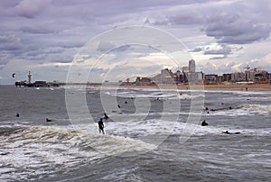 Winter beach in The Hague with surfers, Netherlands