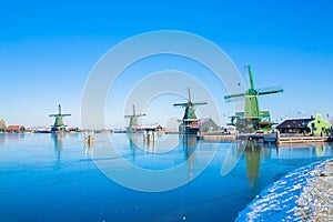 Winter beautiful Dutch houses, old windmills, frozen water in canals and rivers