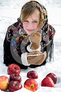 Winter.Beautiful girl with red apples on snow