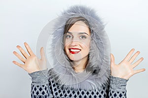 Winter beauty fashion. Beautiful face girl with trendy fur hat gesturing. Emotions. Professional makeup and manicure