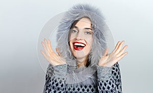 Winter beauty fashion. Beautiful face girl with trendy fur hat gesturing. Emotions. Professional makeup and manicure