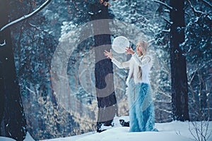 Winter Beauty Woman. Beautiful fashion model girl with snow hairstyle and makeup in the winter forest. Festive makeup and manicure