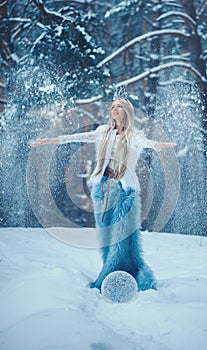 Winter Beauty Woman. Beautiful fashion model girl with snow hairstyle and makeup in the winter forest. Festive makeup and manicure