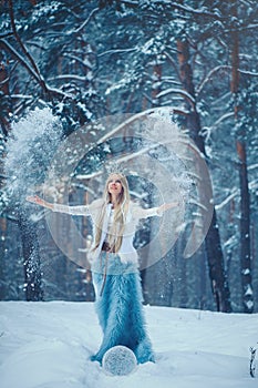 Winter Beauty Woman. Beautiful fashion model girl with snow hairstyle and makeup in the winter forest. Festive makeup and manicure