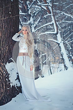 Winter Beauty Woman. Beautiful fashion model girl with snow hairstyle and makeup in the winter forest. Festive makeup and manicure