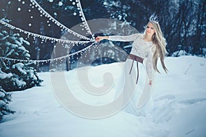 Winter Beauty Woman. Beautiful fashion model girl with snow hairstyle and makeup in the winter forest. Festive makeup and manicure