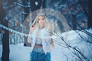 Winter Beauty Woman. Beautiful fashion model girl with snow hairstyle and makeup in the winter forest. Festive makeup and manicure