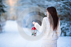 Winter beauty. Woman holding Christmas lantern outdoors on beautiful winter snow day