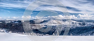 Winter Beskids mountains panorama with snow, hills and blue sky with clouds